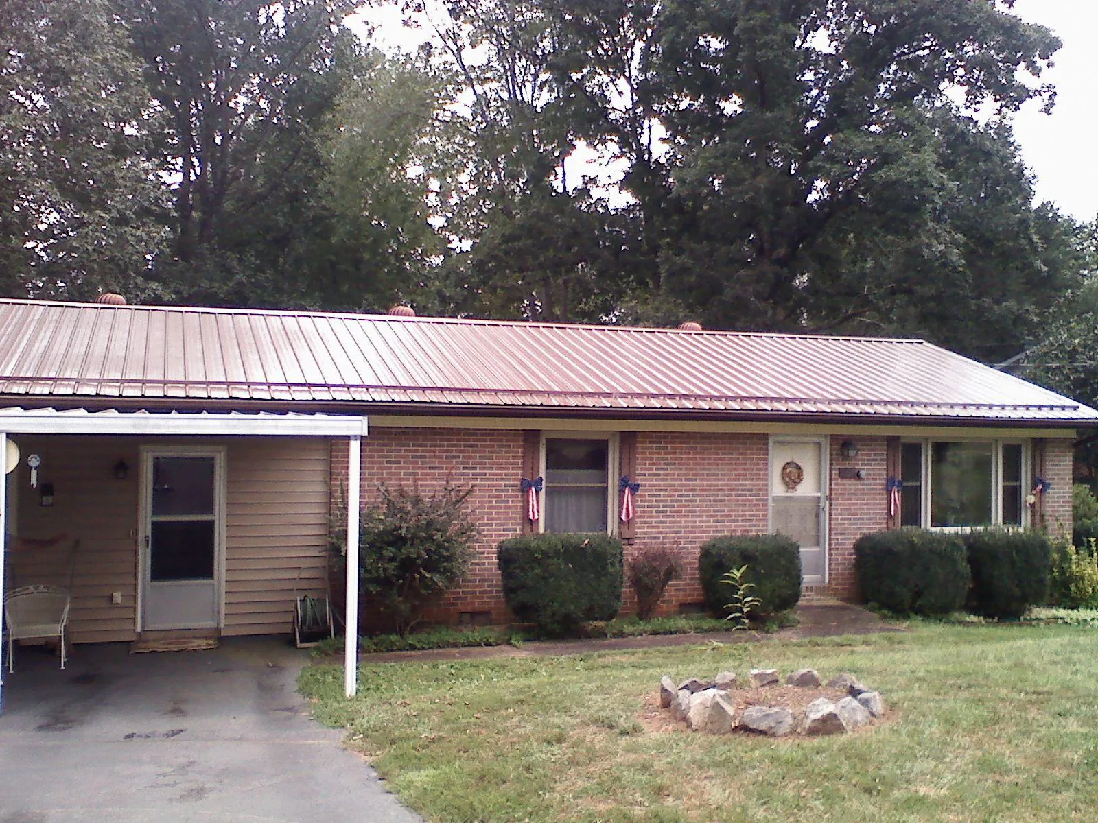 Bronze metal roof and carport on a brick ranch home — Roof Repair work by our crew in Ocheyedan